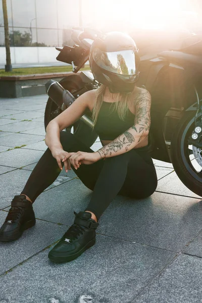 Женщина в черном шлеме и мотоцикле на городской улице — стоковое фото