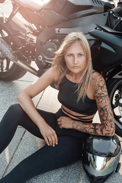 Mulher posando com motocicleta à luz do sol — Fotografia de Stock