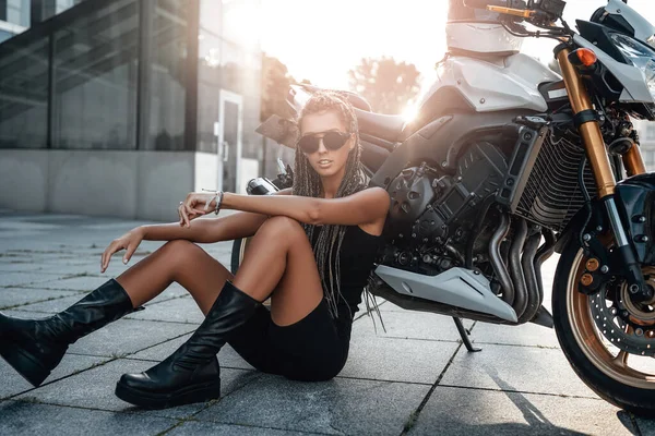 Rahat bayan motosikletçi asfalt üzerinde oturuyor.