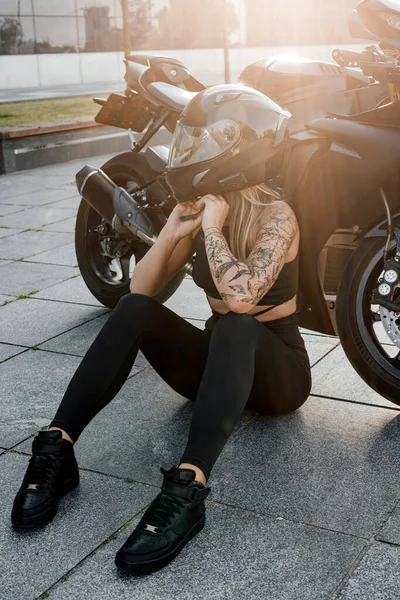 Γυναίκα με μαύρο κράνος και μοτοσικλέτα στην οδό της πόλης — Φωτογραφία Αρχείου