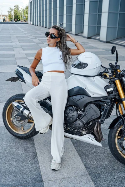 Shot of stylish woman biker leaning her motorcycle outside — ストック写真