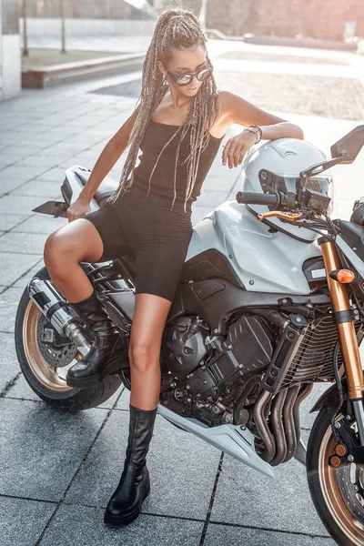 Vrouwelijke motorrijder met urban motor buiten op de stoep — Stockfoto