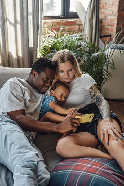 Multi familia étnica de pareja y su hija en la cama — Foto de Stock