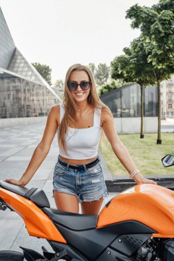 Gülümseyen kadın ve turuncu bisiklet