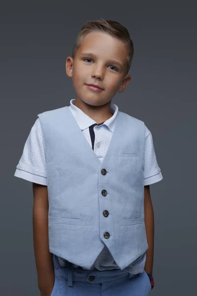 Cool jongen gekleed in de zomer kleding poseren tegen grijze achtergrond — Stockfoto