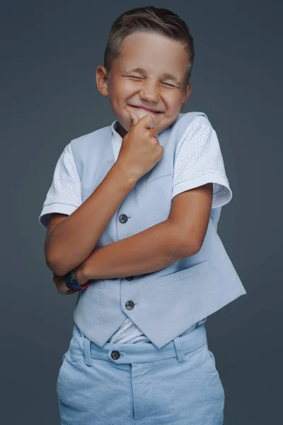 Speelse kleuter poseren tegen grijze achtergrond — Stockfoto