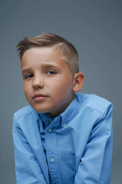 Studio shot van schattige jonge jongen gekleed in blauw shirt — Stockfoto