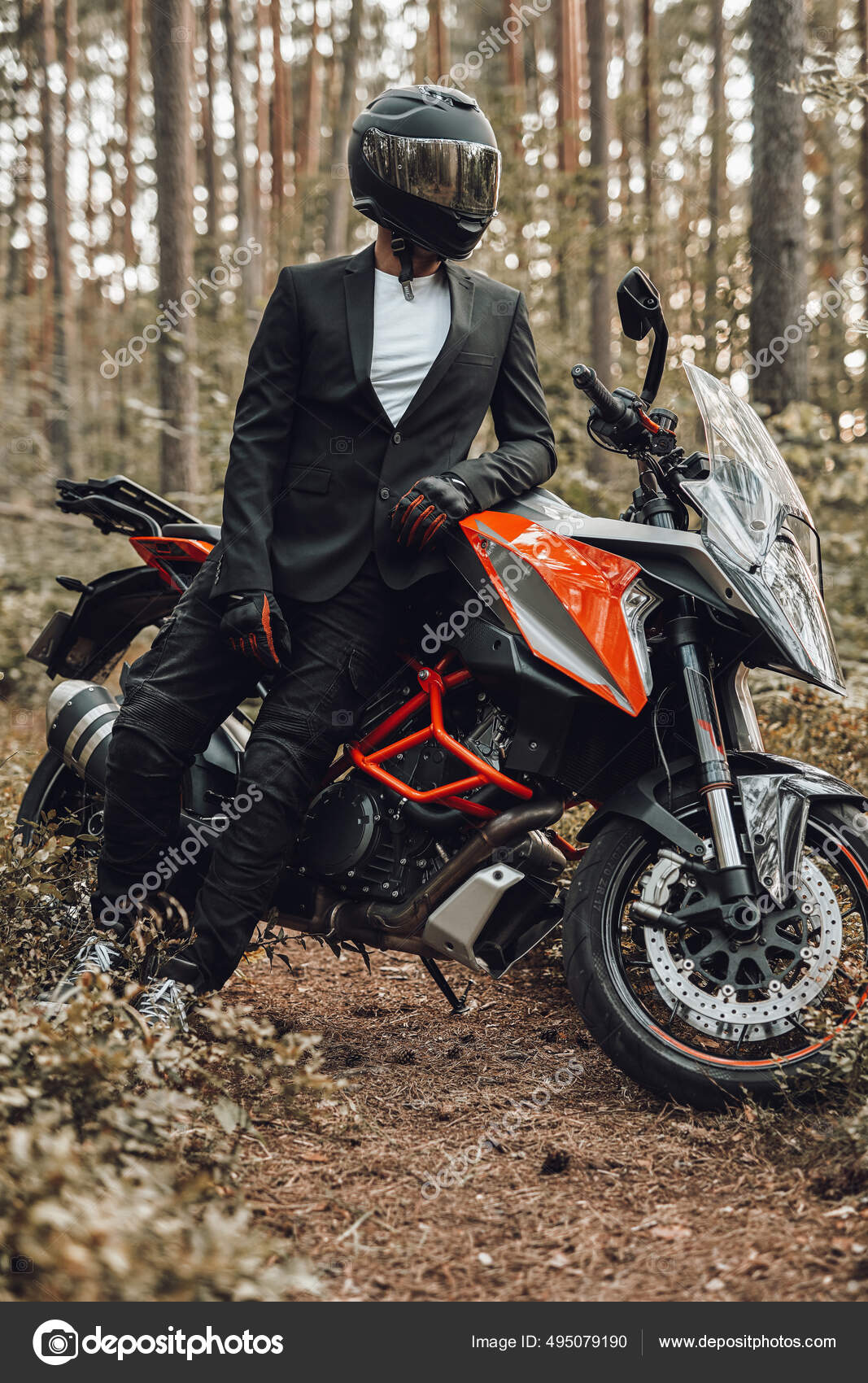 Hombre vestido de traje negro con motocicleta oscura en el bosque:  fotografía de stock © fxquadro #495079190