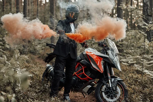 森の中で彼の手から行くカラフルな煙とオートバイ — ストック写真