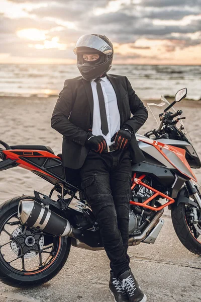 Uomo d'affari motociclista che riposa sulla spiaggia con la sua moto personalizzata — Foto Stock