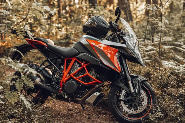 現代の黒赤のオートバイとヘルメットで森の中 — ストック写真