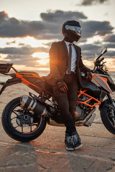 Homem vestido de terno e capacete posando na praia com bicicleta — Fotografia de Stock