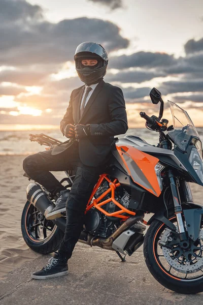 Cool uomo d'affari con casco moto in posa contro il paesaggio marino — Foto Stock