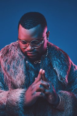 Siyah arka planda lüks kıyafetler giyen Afrikalı bir adam.