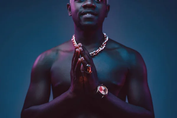 African man keeping his hands together against dark background — Stock Photo, Image