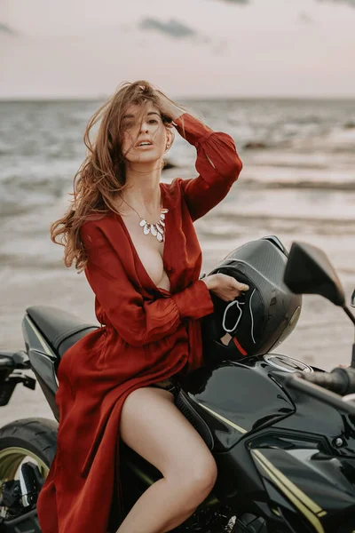 美人バイカー座って上の黒オートバイに対して海 — ストック写真