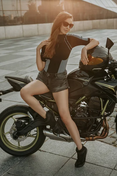 Κομψό θηλυκό μοτοσικλετιστής ντυμένος με σκούρα ρούχα έξω — Φωτογραφία Αρχείου
