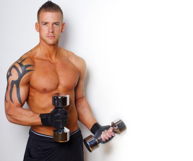 İyi görünümlü vücut sıcak adamla dumbbells tutuyor