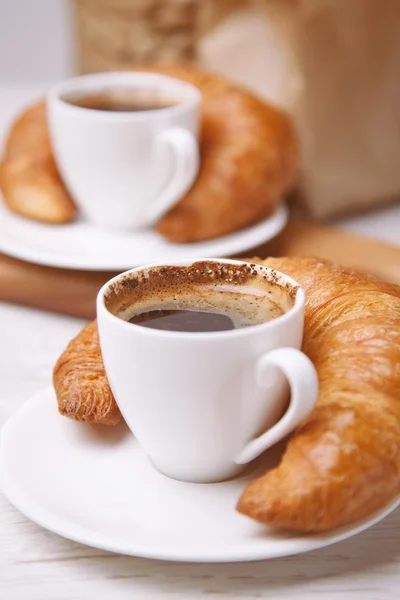 Twee kopjes koffie en croissants ernaast — Stockfoto