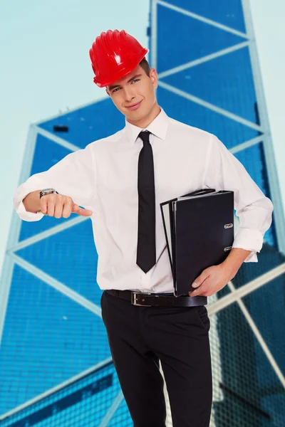 Joven chico agradable en hardhat con carpetas — Foto de Stock