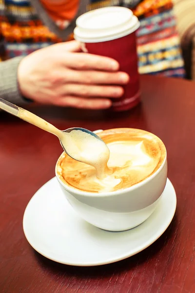 Xícara de café e colher que está em espuma — Fotografia de Stock