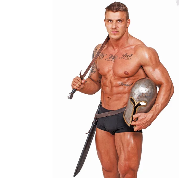 Serious man in pants only with helmet and sword — Stock Photo, Image