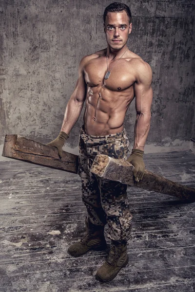 Сильний атлетичний чоловік з голим тілом у військових штанах — стокове фото