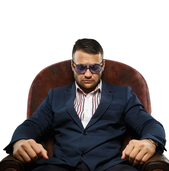 Güneş gözlüklü bir koltuk üzerinde ciddi bir adam — Stok fotoğraf