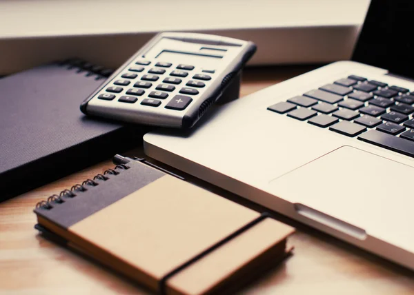 Um novo computador portátil com notebooks e uma calculadora — Fotografia de Stock