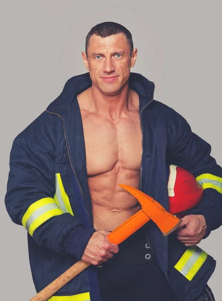 Portrait of fireman posing on grey background — Stock Photo, Image