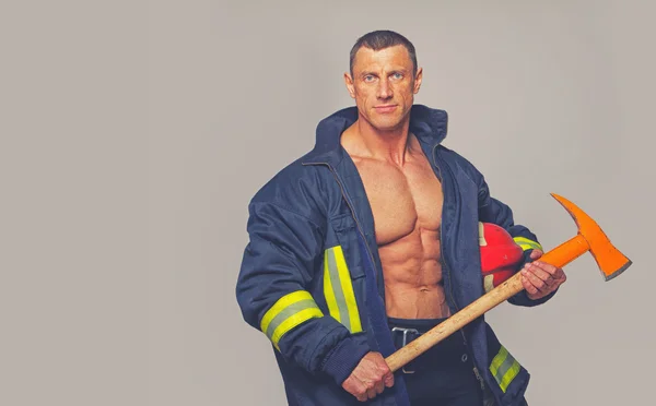 Ritratto di uomo muscoloso in uniforme da pompiere — Foto Stock