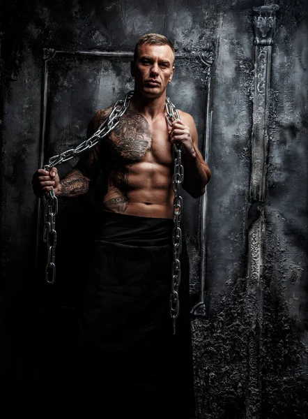 Мускулистый сильный мужчина с татуировкой — стоковое фото