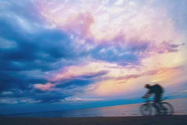 Mountain biker on beach and sunset — Stock Photo, Image