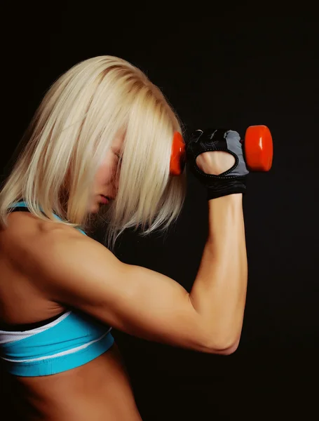 Gut geformtes athletisches Mädchen bedeckt ihr Gesicht mit blonden Haaren — Stockfoto