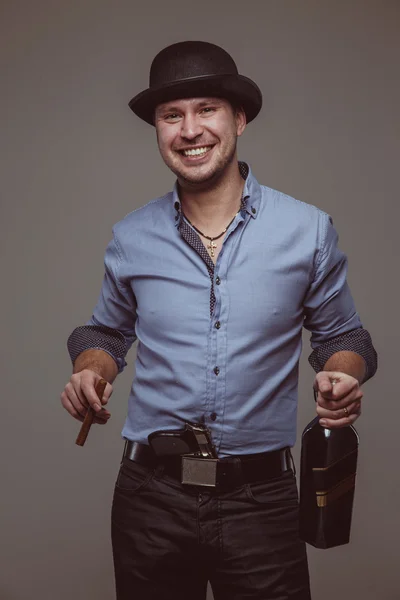 Man with pistol smiles with alcohol and cigar — Stock Photo, Image
