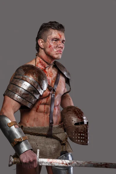 Verwundeter Gladiator mit muskulösem Körper in Rüstung — Stockfoto