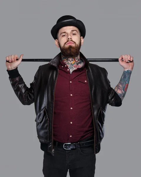 Tattoed gangster in hat holding walking-stick — Stock Photo, Image