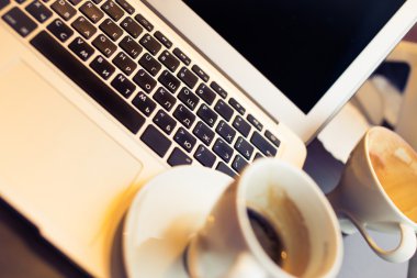 Bardak kahve ve bir dizüstü bilgisayar