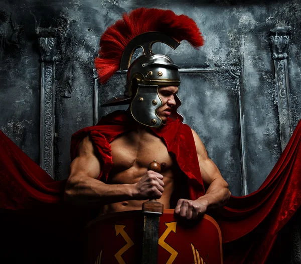 Muscular warrior holds shield and sword — Stock Photo, Image