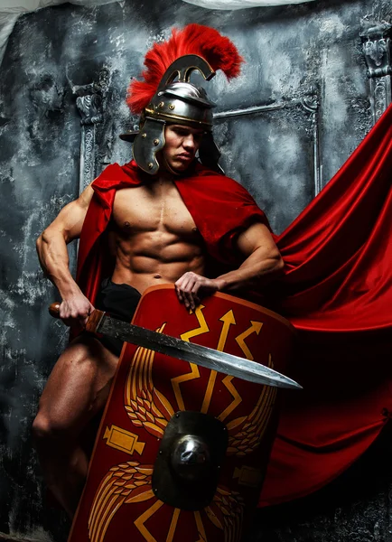 Muscular warrior holds shield and sword — Stock Photo, Image