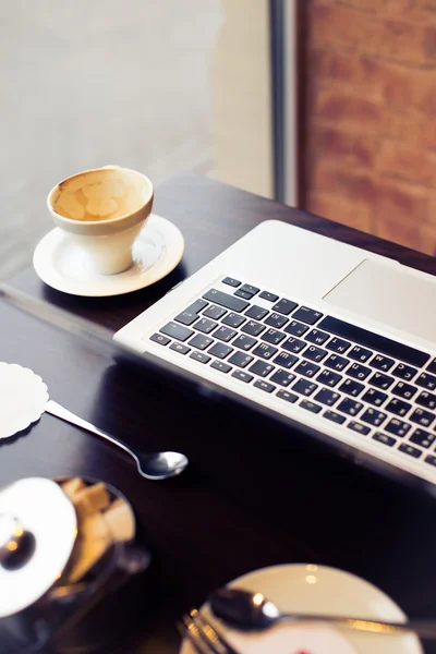 Laptop and cup of coffee with sugar bowl — Stock Photo, Image