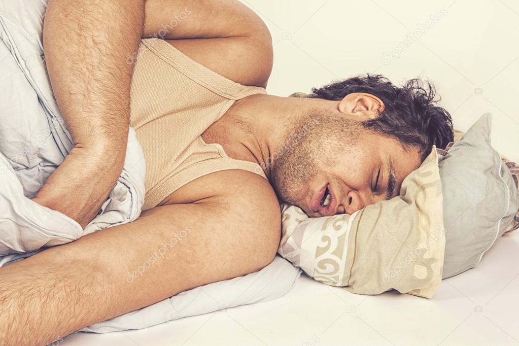 Young man sleeping in bed 