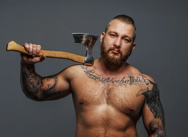 Brutal big man with tattooes and beard holding axe — Stock Photo, Image