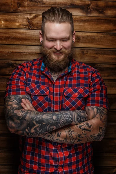 Brutal enorme macho com barba e tatuagens com sorriso no rosto — Fotografia de Stock