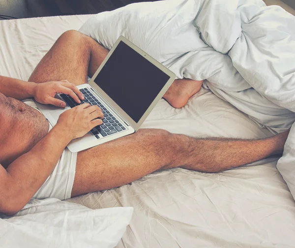 Jovem usando um laptop em casa — Fotografia de Stock