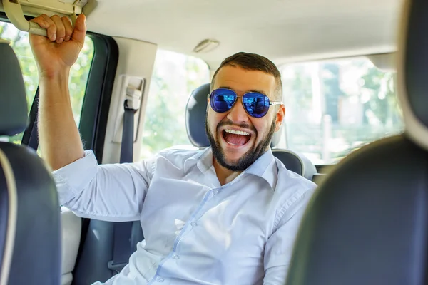 Happy male wit beart and tattoe in a car. — Stock Photo, Image