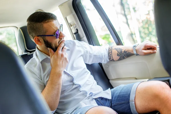 Šťastný muž vtipu Béart a tattoe v autě. — Stock fotografie