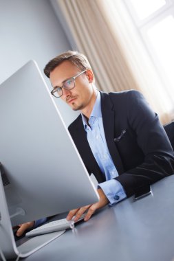 Bilgisayarla çalışma yakışıklı iş adamı.