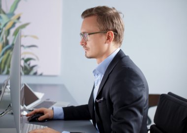 Bilgisayarla çalışma yakışıklı iş adamı.