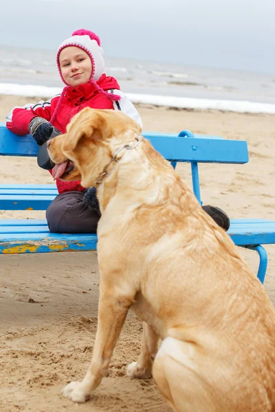 Weinig meisje possing met een hond. — Stockfoto